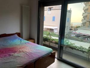 um quarto com uma cama e uma grande janela em Bilocale vista mare em Cattolica