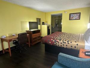 a hotel room with a bed and a desk with a computer at Econo Lodge in Picayune
