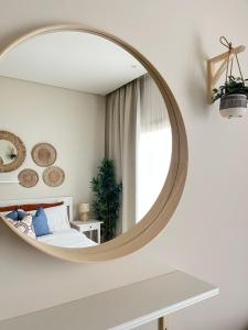 ein Schlafzimmer mit einem großen runden Spiegel an der Wand in der Unterkunft Jebel Sifah Golf View Apartment in Muscat