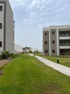 um passeio vazio em frente a um edifício em Jebel Sifah Golf View Apartment em Mascate