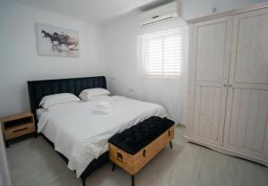 a bedroom with a large bed with a black headboard at Netanya Central SEA & SHOP in Netanya