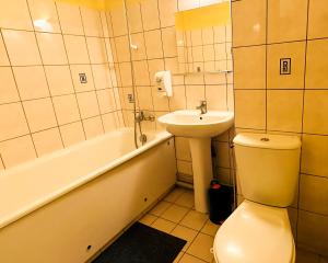 ein Badezimmer mit einem WC, einem Waschbecken und einer Badewanne in der Unterkunft Hôtel Le Valéran in Ligny-en-Barrois
