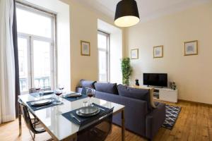 a living room with a blue couch and a table at Ola Lisbon - Chiado 1 in Lisbon