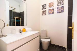a bathroom with a white sink and a toilet at Ola Lisbon - Chiado 1 in Lisbon +6 photos