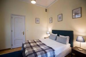 a bedroom with a bed and two lamps and a door at Ola Lisbon - Chiado 1 in Lisbon
