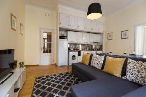 a living room with a blue couch and a kitchen at Ola Lisbon - Chiado 1 in Lisbon