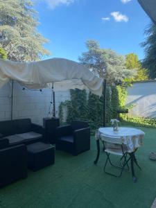 a patio with a table and a white umbrella at Appartamento con Giardino in Seregno