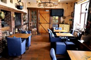 un restaurante con sillas y mesas azules y TV en Domaine "Le Ry d'Ave", en Rochefort
