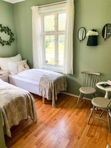 a bedroom with a bed and a window and a chair at Petrines Gjestgiveri in Norddal