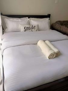 1 cama blanca grande con 2 toallas en Blue Falls Queen Studio en Nairobi