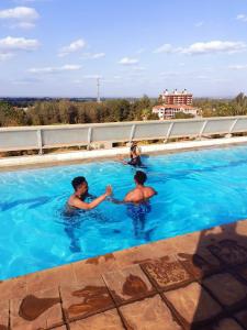 Dos personas están jugando en una piscina en Blue Falls Queen Studio en Nairobi
