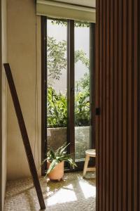 a room with a window and a potted plant at Teva Tulum, Aldea Zamá in Tulum