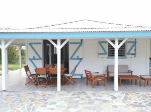 un pabellón con una mesa y sillas en un patio en 971B - La Villa ROUYO, villa créole accessible PMR, en Le Moule