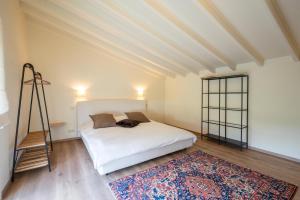 1 dormitorio con cama blanca y alfombra en House On The Green, en Waregem