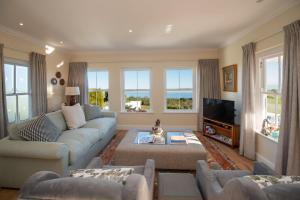 a living room with a couch and a tv at Greenhill Farm Parklands Cottage - 2 bedroom 4 guests - Private House in Plettenberg Bay