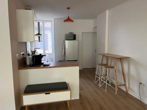 a small kitchen with a counter and a refrigerator at Les clos de Givry - Clos Léonie - Appartement 68m2 spacieux, lumineux et avec sauna in Givry