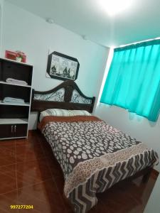 a bedroom with a bed and a window with blue curtains at Departamento-Bolognesi B1 in Chiclayo