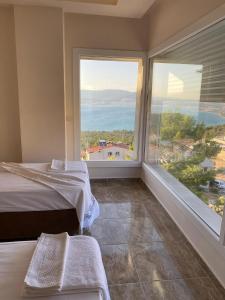 a bedroom with a bed and a large window at Dilbar Villa in Akbük