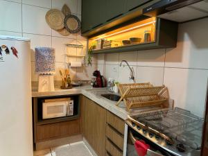 uma pequena cozinha com um lavatório e um micro-ondas em Apê Central Bonito em Bonito