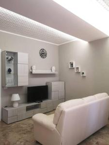 een witte woonkamer met een witte bank en een televisie bij Montelepre Sweet Home casa vacanze in Montelepre