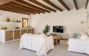 sala de estar con muebles blancos y TV en Ca Na Bennassar Pollensa - BY EMERALD STAY en Pollença