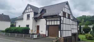 ein Schwarz-Weiß-Haus mit Garage in der Unterkunft Ferienwohnung "Fernblick" Wolzhausen in Breidenbach