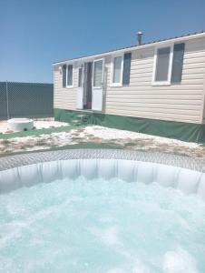 una grande piscina d'acqua davanti a una casa di Tiny house Chill escape para 7 - private Jacussy Brisa & Burbujas a Chiclana de la Frontera