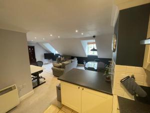 a kitchen and living room with a couch and a table at Modern loft retreat in the heart of Nailsworth in Nailsworth