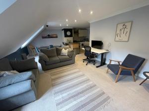 a living room with a couch and a table at Modern loft retreat in the heart of Nailsworth in Nailsworth