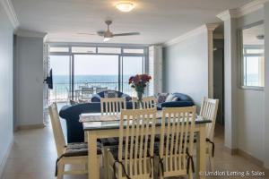 a dining room with a table and chairs with a view of the ocean at COZUMEL 213 in Umdloti