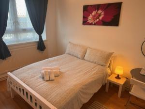 a bedroom with a bed with two towels on it at Beautiful Rooms close to Brick Lane in London