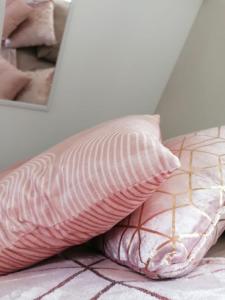 米羅的住宿－Suite La Marquise，一张粉红色枕头坐在镜子旁的床上