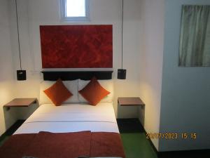 a bedroom with a large bed with orange pillows at My city Beds in Kandy