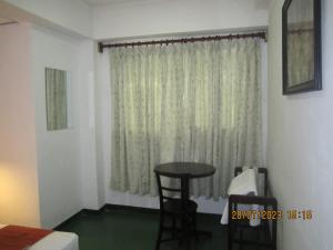 a room with a table and a window at My city Beds in Kandy