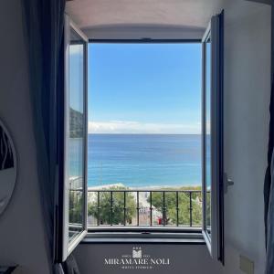 a room with a window with a view of the ocean at Hotel Miramare in Noli