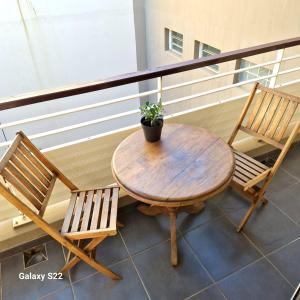 d'une table en bois et de deux chaises sur un balcon. dans l'établissement Studio Leu Loft, à Saint-Leu