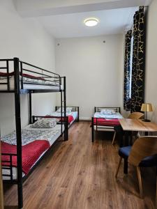 a room with two bunk beds and a table at Hostel KASZUBSKA in Wrocław