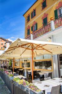 a restaurant with tables and umbrellas in front of a building at Hotel Miramare in Noli