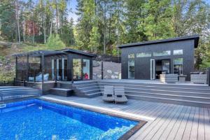 ein Haus mit einem Pool und einer Terrasse in der Unterkunft Newly built Luxurious Guest house in Åkersberga