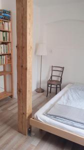 una camera con letto, sedia e libreria di Apartmán Malá Turná a Strakonice
