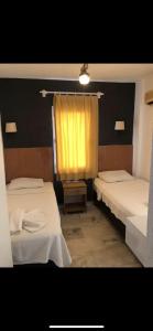 una camera con due letti e una tenda gialla di Kılavuz otel a Bodrum City
