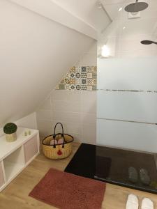 a attic bathroom with a shower and a rug at Suite La Marquise in Murol