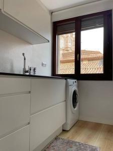 a kitchen with a washing machine and a window at Apartamento Las Vistas in Teruel