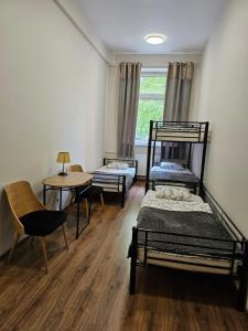 a room with two bunk beds and a table and chairs at Hostel KASZUBSKA in Wrocław