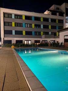 a swimming pool in front of a building at night at Sunlight Studio in Balatonföldvár