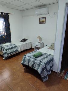 - une chambre avec deux lits et une table avec une lampe dans l'établissement RESIDENCIAL SIC, à Aimogasta