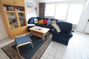 ein Wohnzimmer mit einem blauen Sofa und einem Couchtisch in der Unterkunft Appartmenthaus Nordlicht in Cuxhaven