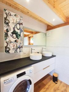 a bathroom with two sinks and a washing machine at Cabanes du Domaine des Fées in Dole