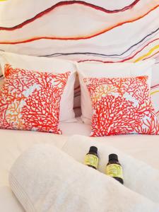two bottles of honey sitting on a bed with pillows at Cabanes du Domaine des Fées in Dole