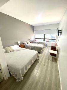 Habitación de hotel con 2 camas y ventana en Apart hotel Ciudad de Bs As en Buenos Aires
